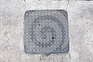 Metal hatch sewer manhole on pavement