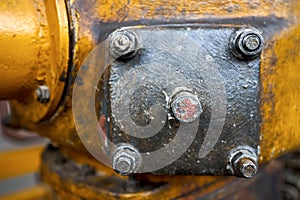 Metal hatche plate of compressor for revision close-up painted with yellow paint bolted with studs and nuts background