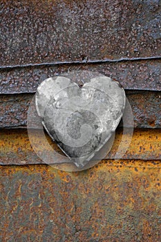 Metal heart on rusty background