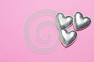 Metal hearts on pink background. Mothers Day or Valentines Day concept