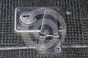 Metal inbuilt lock of the old hardshell suitcase close-up
