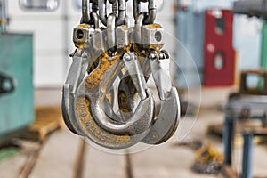 Metal industrial chains with hooks in the workshop of a metallurgical plant. Close-up. Lifting hooks for lifting heavy materials