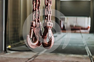 Metal industrial chains with hooks in the workshop of a metallurgical plant. Close-up. Lifting hooks for lifting heavy materials