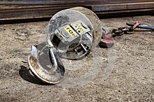 Metal industrial hook on the concrete floor of a steel plant. Close-up. Lifting hooks for heavy materials and equipment. Cargo