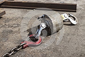 Metal industrial hook on the concrete floor of a steel plant. Close-up. Lifting hooks for heavy materials and equipment. Cargo