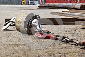 Metal industrial hook on the concrete floor of a steel plant. Close-up. Lifting hooks for heavy materials and equipment. Cargo