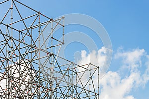 Metal industrial scaffolding construction site structure blue cloudy sky background with copy space