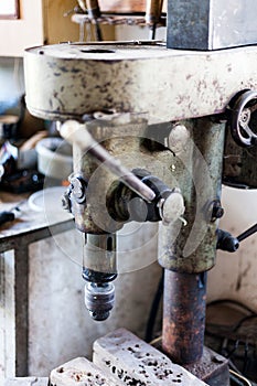 Metal industry stand with drill machine. Home workshop with hard tools on the metal stand. Old rusty hand tool drill