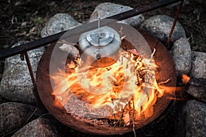 Metal kettle on a campfire