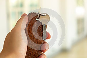 Metal Key and Wooden Keychain in Male Hand