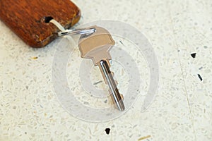 Metal Key and Wooden Keychain on the Terrazzo Table