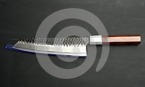 Metal kitchen knife with wooden handle on black background