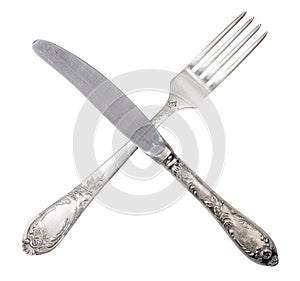 Metal knife and fork crossed isolated on white