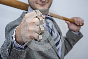 Metal knuckles in a man`s hand, a wooden bat behind his back, a prohibited weapon in a fight, a heavy blow, street thugs, urban