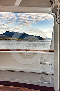 Metal ladder rungs on cruise ship deck with view of mountain scenery in background ner Ketchikan, Alaska.