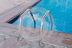 Metal ladder to descend to the swimming pool. Clear turquoise water in the pool