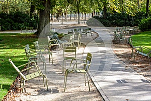 Metal lawn chairs scattered alongside an alley in a public garden