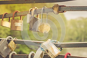 Metal locks locked on a railing/Close up of row of love locks in sunny day