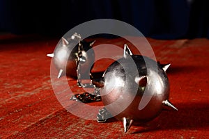 Metal maces on a chain laying on old red carpet