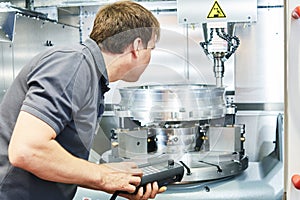 Metal machining industry. Worker operating cnc milling machine photo