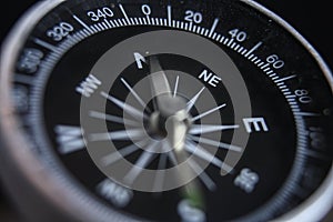 Metal magnetic compass pointing north macro shot background