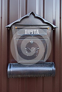 A metal mailbox hangs at the entrance to the gate