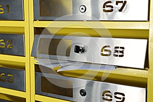 Metal mailboxes with keyholes, numbers and receipts indoors