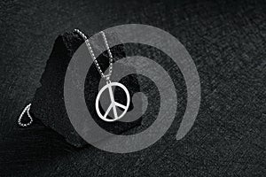 Metal medallion, with a pendant in the form of a mark of peace on a black stone