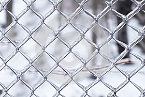 Metal mesh covered with ice close up. Deteriorating weather conditions. Ice cover metal fence