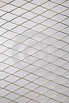 Metal mesh with diamond-shaped cells on a white background, backgrounds, textures