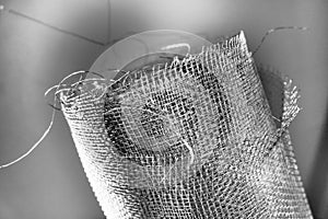 Metal mesh. Rolled mesh in gray. Heavy duty steel or aluminum mesh with ragged edges.