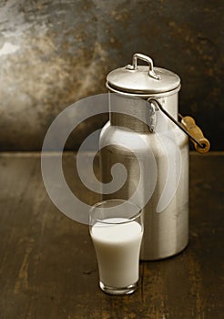 Metal milk can with glass of fresh milk
