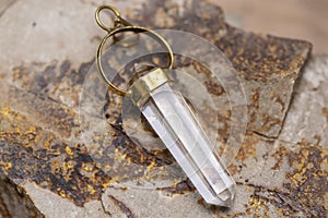 Metal mineral stone pendant on rocky background