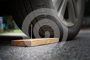 metal nail on board wood nearly to puncture into wheel tire