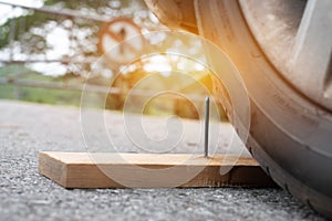 metal nail on board wood nearly to puncture into wheel tire