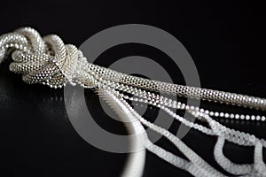 Metal necklace tied in a knot on a dark background