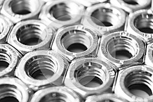 Metal nuts in a row background. Chromed screw nuts . Steel nuts pattern. Set of Nuts and bolts. Tools for work. Black and