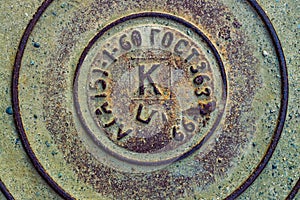 Metal old sewer manhole fragment and the inscription in Russian `GOST`.