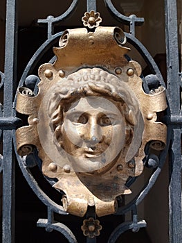 Metal ornament of a face on a gate