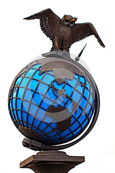 Metal owl with world globe isolated on white background