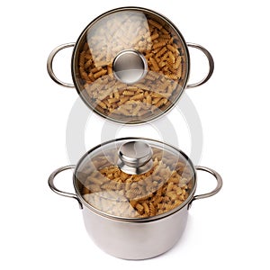 Metal pan with glass lid filled with dry rotini pasta over isolated white background