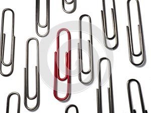 Metal paper clips on a white background. Office supplies isolate. Idea. The concept of loneliness. Confrontation. Stands out from