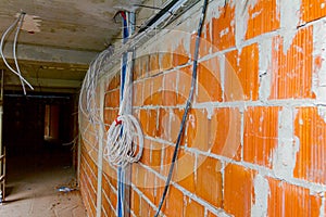 Metal perforated tray with bundle of cables between floors in building