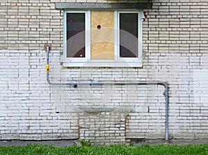 Metal pipe on white brick wall