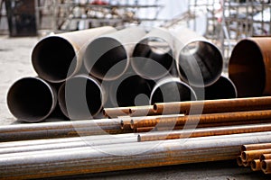 Metal pipes of different diameters are at the construction site. Water, gas and heat supply. Close-up. Shallow depth of field