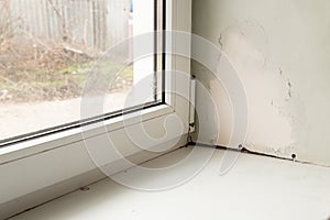 Metal-plastic window in an apartment damaged by mold and moisture close up