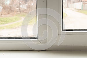 Metal-plastic window in an apartment damaged by mold and moisture close up