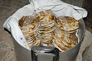 Metal pot on the floor full of small corn bread. Ecuador photo