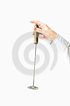 Metal potato masher with a wooden handle in female hands on a white background