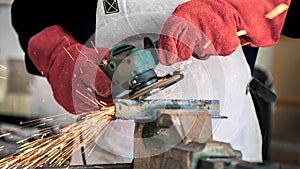 Metal processing with a man using angle grinder to cleaning the steel seam